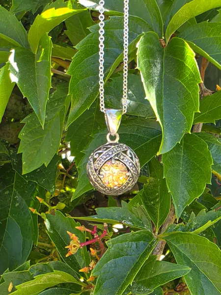 A Strontium Titanate pendant set in sterling silver and accented with diamonds.