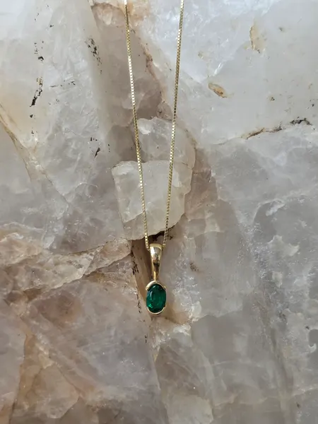 This 14k Gold Necklace features a stunning Emerald.