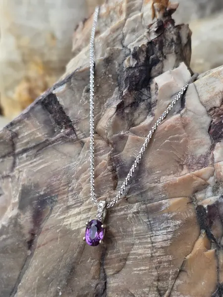 A color changing Sapphire, featuring a small diamond and set in 14k White gold.
