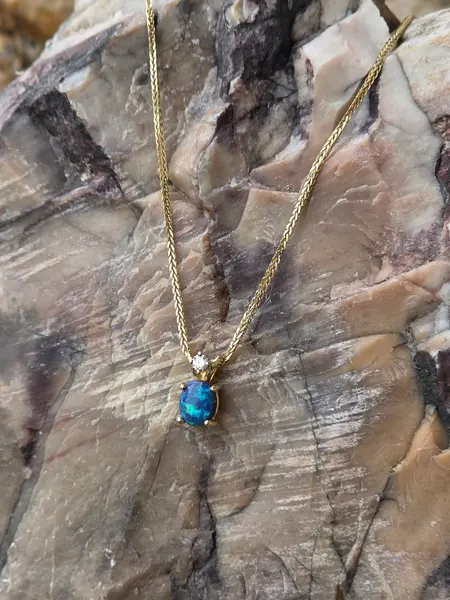 This Gorgeous Australian Black Opal pendant features 1 VS diamond and is set in 14k Gold.