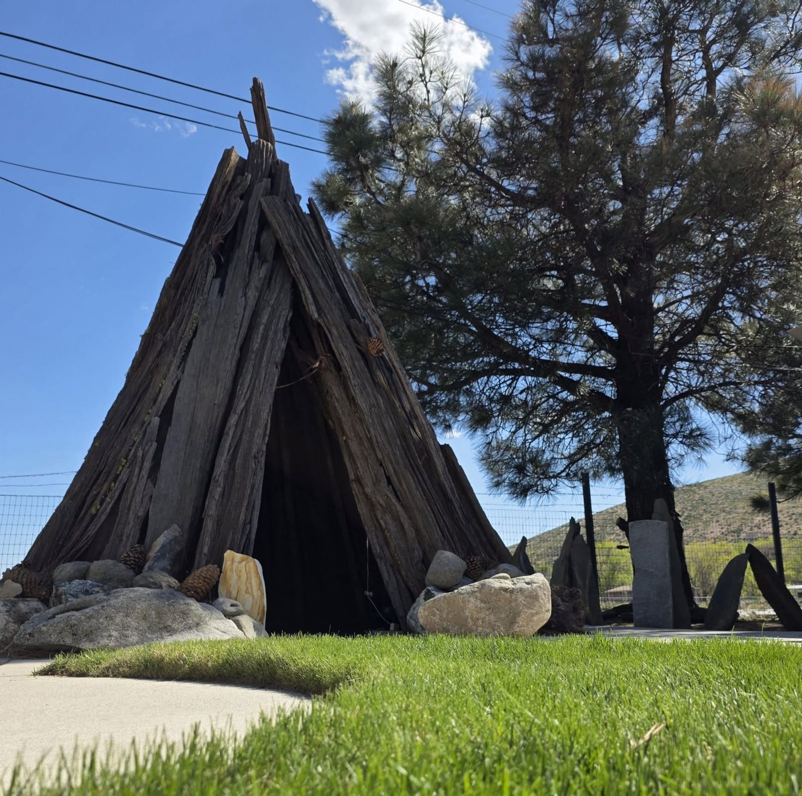 The wooden tipi outside Rupert's Precision Gemcutting on South Curry Street — the landmark to look for.